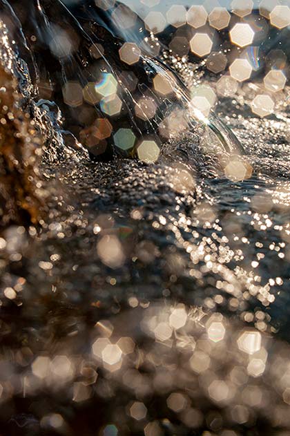 An einer Kaskade fällt das Flußwasser Gischt spritztend herab